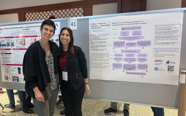 Elva and Marisa pose in front of research poster.